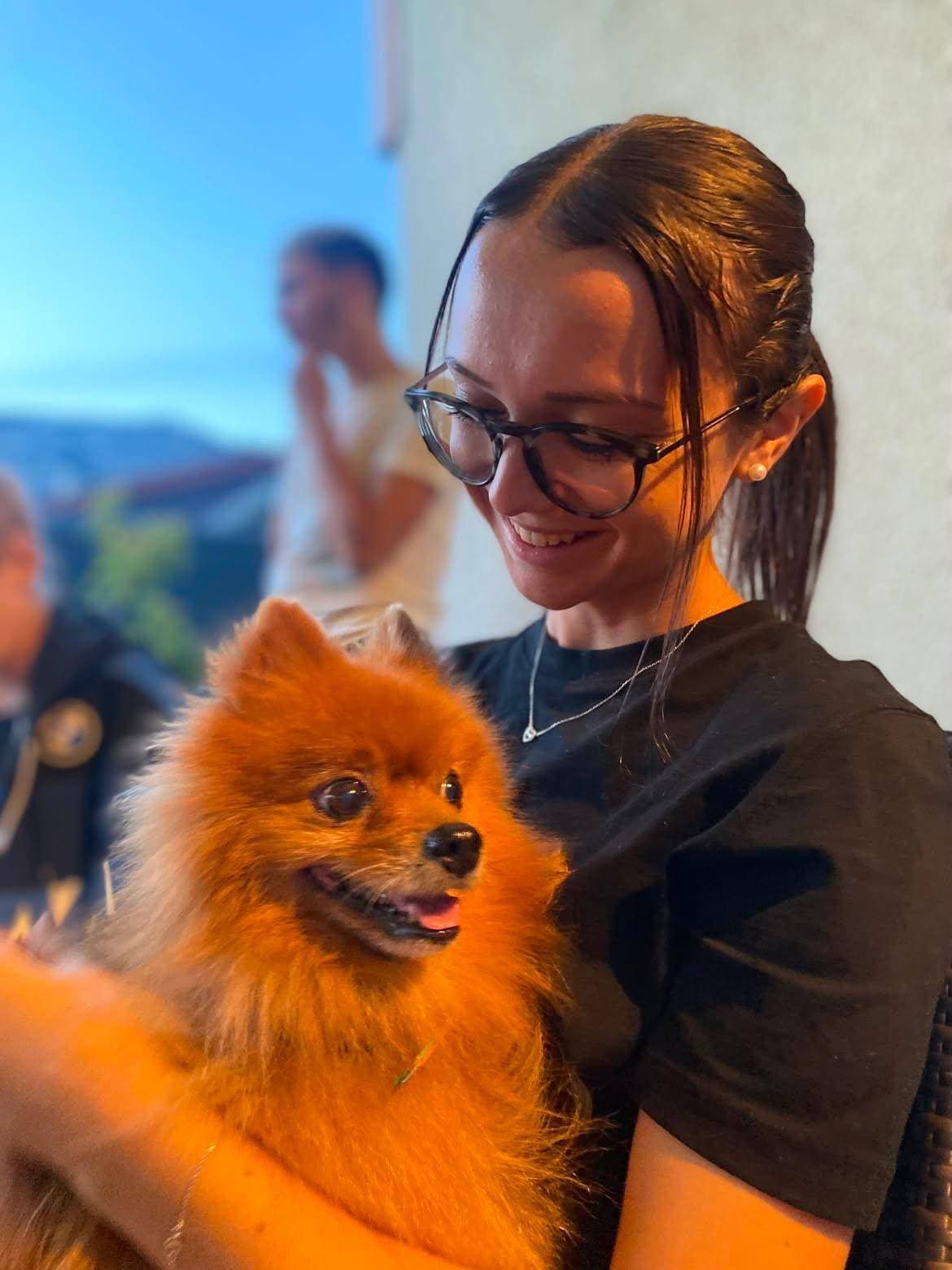 Eva accroupie dans l’herbe, un chien contre elle